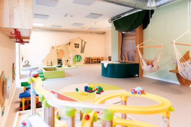 Heller Indoor-Spielbereich mit Kletterhaus und Spielzeug