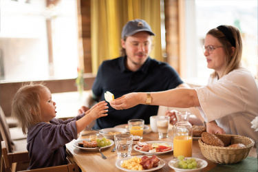 Vater, Mutter und Kind frühstücken gemeinsam